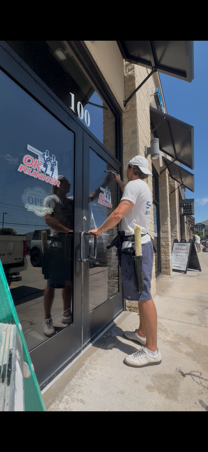 Shine Brothers cleaning a storefront door