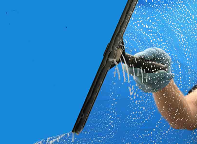 Close-up of a squeegee pulling suds down a clean window